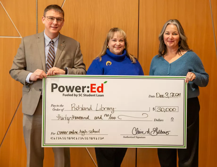 Executives pose with ceremonial check