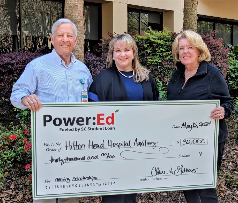 Executives pose with ceremonial check