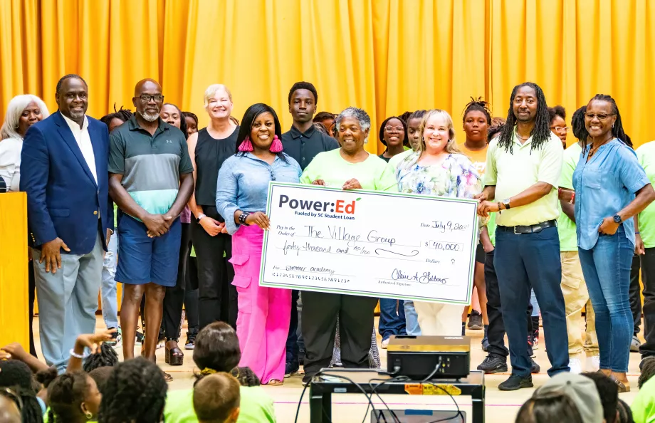 Executives pose with ceremonial check