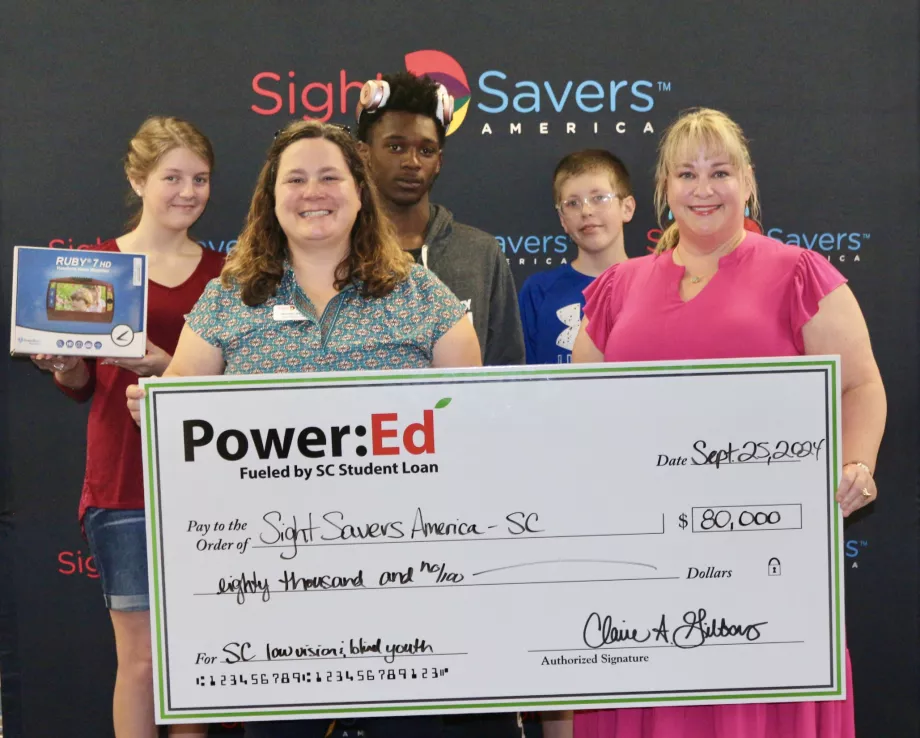 Students and adults pose with big ceremonial check