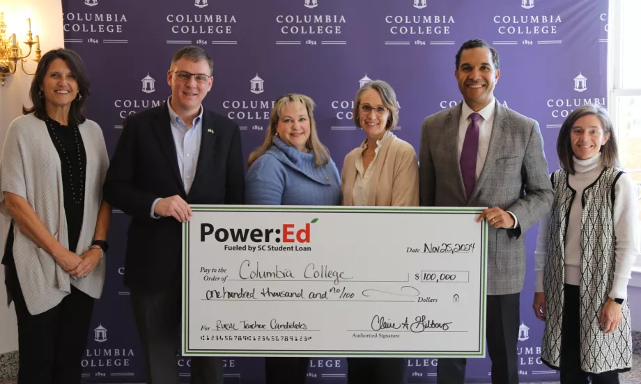 Executives pose with ceremonial check