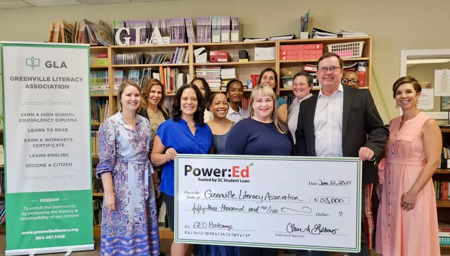 Executives pose with ceremonial check