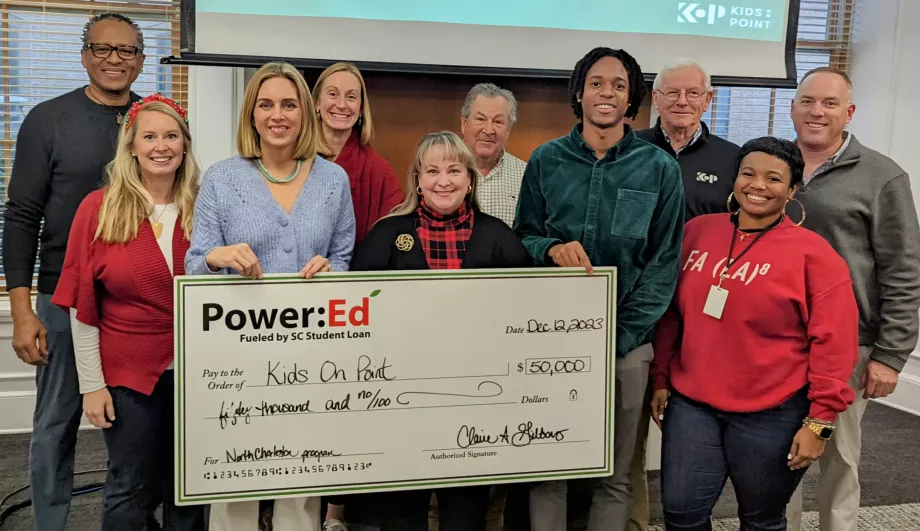 Executives pose with ceremonial check