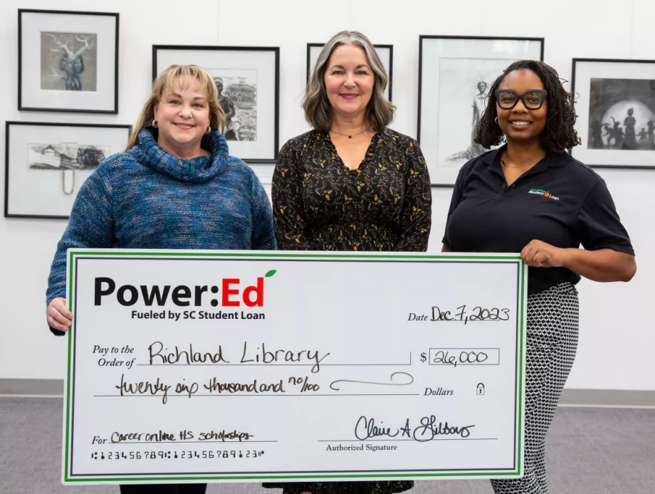 Executives pose with ceremonial check